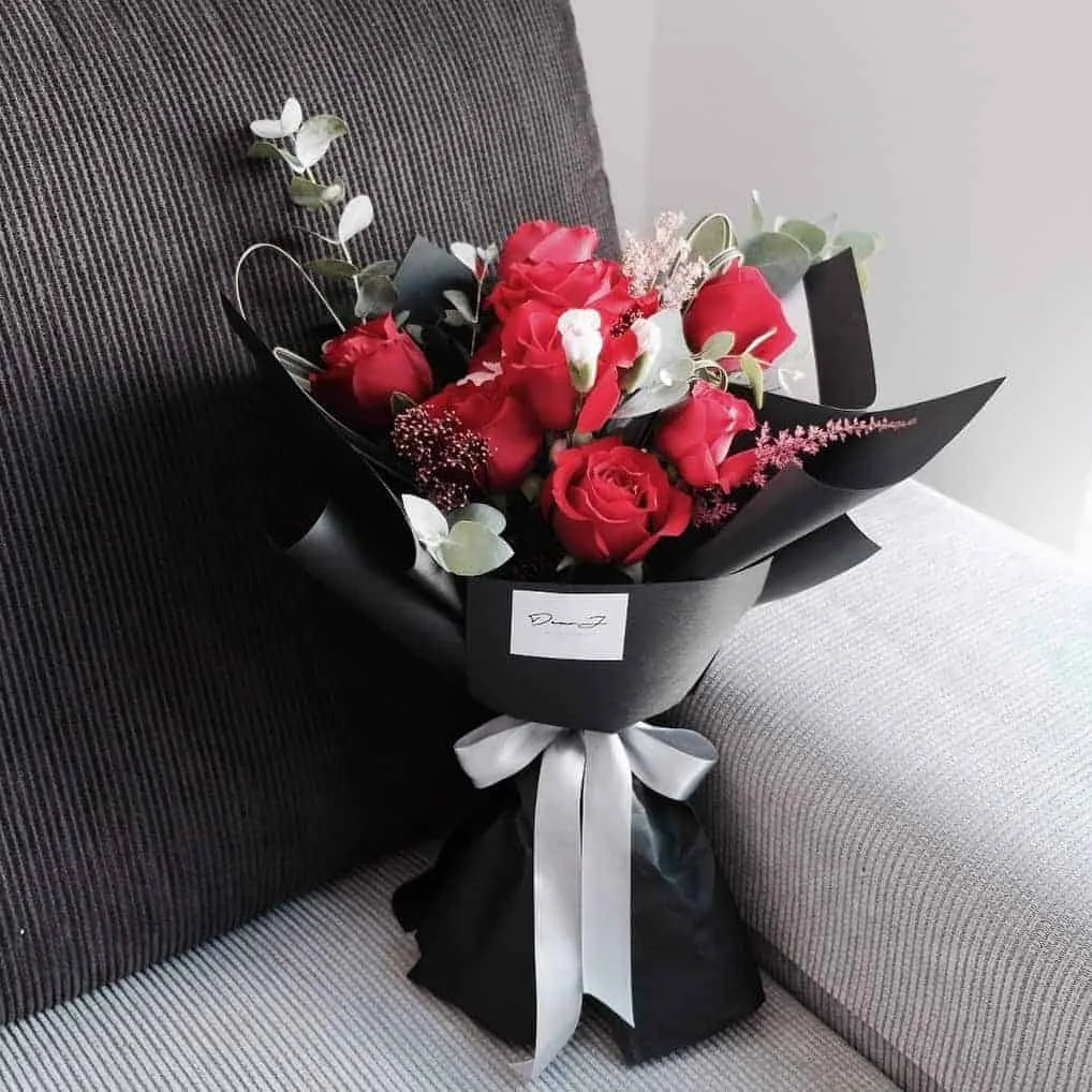 9 red Roses, Astilbe, Spray Carnation, Skimmia Red Rubella, foliage and Eucalyptus.